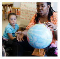 Teacher and student looking at globe