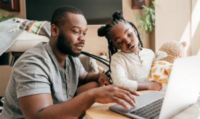 A parent browsing the computer with a child from home