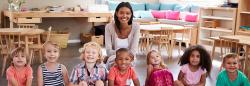 One teacher and seven children posing for a picture during circle time