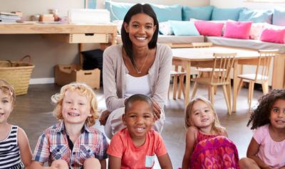 One teacher and seven children posing for a picture during circle time