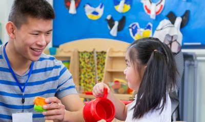 Teacher and student playing in kitchen learning center