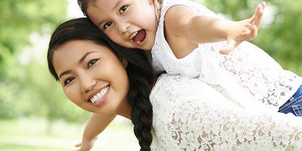 Young girl on her mother's back outside