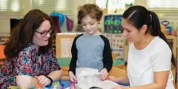 Teacher meets with parent and child at a conference