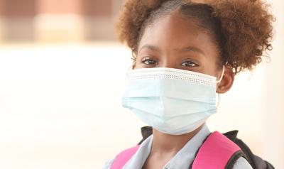 Young girl in a mask with a backpack on