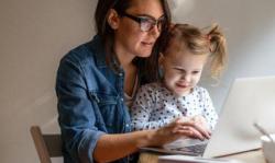 mother and daughter typing on a laptop