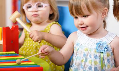 Two toddlers playing with xylophone