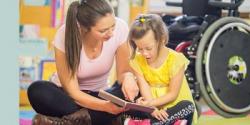 Teacher helping child read a book