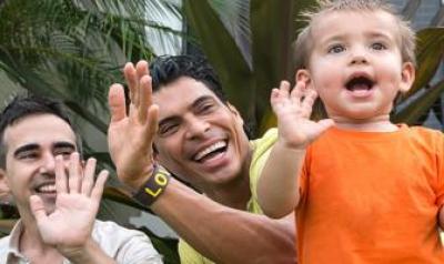 Two fathers playing with son outside 