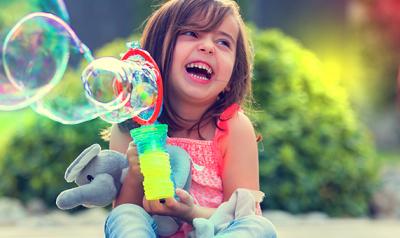 young child plays with bubbles