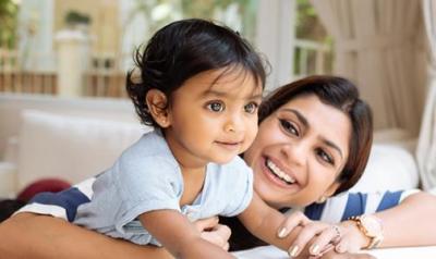 Mother holding and laughing with baby girl