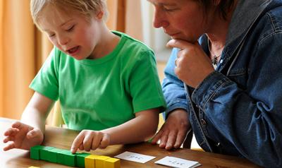 Mother and son reading cards and counting blocks