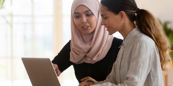 Two women looking at a laptop