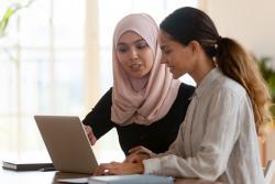 Two women looking at a laptop