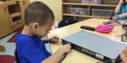 A child plugging in a projector screen.