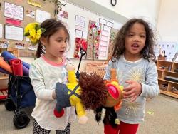 Two children playing with a puppet.