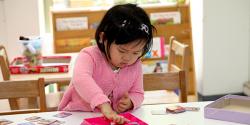 A young child playing with cards on a table.