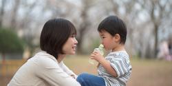 Mother and son sitting on a picnic table outside