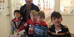 Teacher and students smiling with artwork