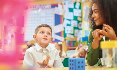 A young boy practices counting with his teacher.