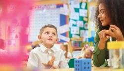 A young boy practices counting with his teacher.