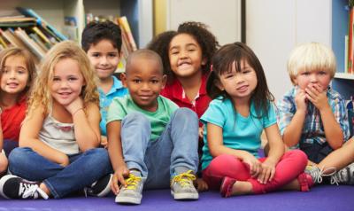 A diverse group of young children looking forward to a read aloud