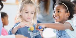 Two toddlers playing with modular solar system