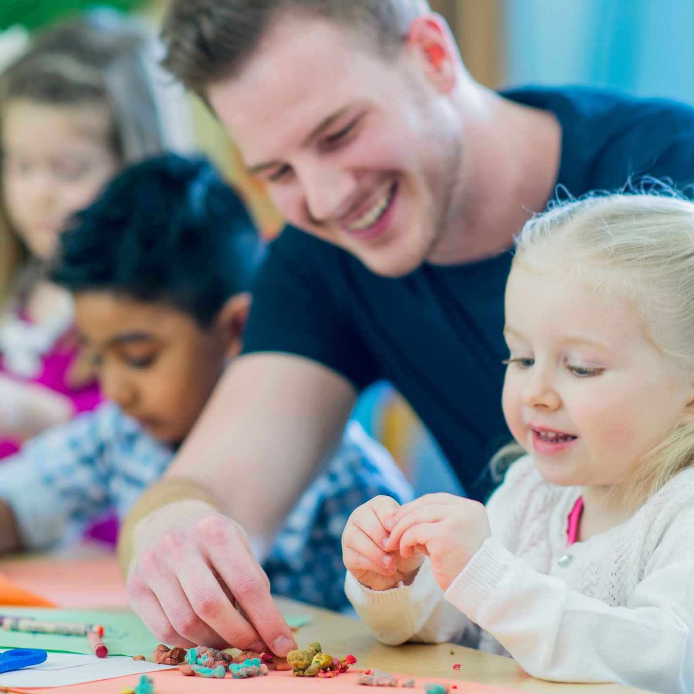 Male teacher helping students