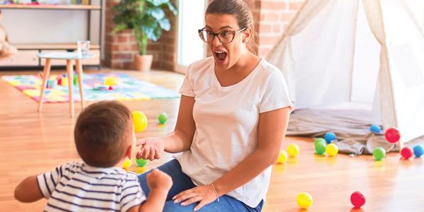 a teacher excited with a child playing with toys