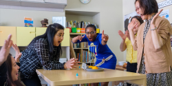 a teacher observing a craft project with children