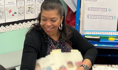 a teacher reading a book to children