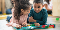 two children on the floor reading together