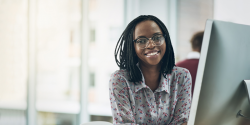 woman sitting in front of her computer getting ready to engage in virtual learning and collaboration remotely with team members.