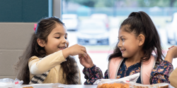 Two children talking about their lunch 