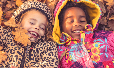 Three girls playing in leaves