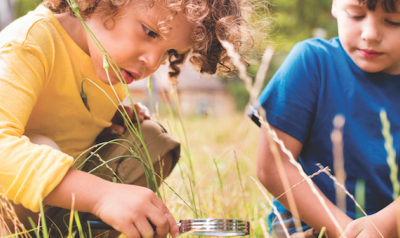 Two kids looking through magnifying glass