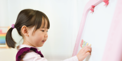 a child writing on a whiteboard