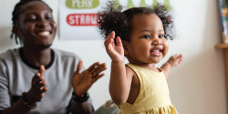 an adult and child happily clapping