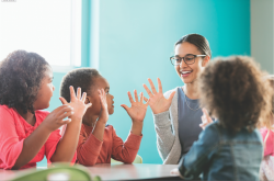 Teacher and students with hands up