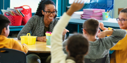 a teacher responding to children raising their hands