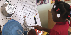 a child sorting items on a peg board